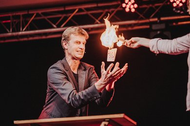Zauberer Bjørn de Vil vollführt einen Kartentrick mit Flammen.