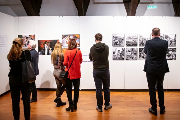 Bild: Nika Kramer Eine Reihe Personen steht vor den Exponaten in der World Press Photo Ausstellung.