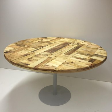 Eine runde Holzplatte mit einem Metallfuß ergibt einen Tisch.