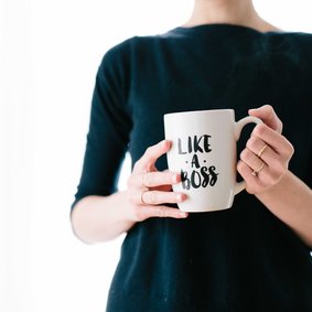 Eine Person hält einen Kaffeebecher mit der Aufschrift Like a Boss.