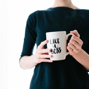 Eine Person hält einen Kaffeebecher mit der Aufschrift Like a Boss.