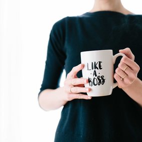 Eine Person hält einen Kaffeebecher mit der Aufschrift Like a Boss.