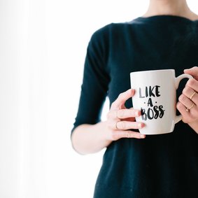Eine Person hält einen Kaffeebecher mit der Aufschrift Like a Boss.