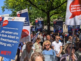 Viele Menschen demonstrieren mit Plakaten.