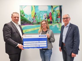 Herrmann Kruse überreicht Anita Grothund Andreas Gögel einen symbolischen Spendenscheck.