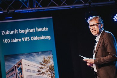 Matthias Welp, Leiter des Amtes für Schule und Bildung der Stadt Oldenburg, spricht ein Grußwort zum Jubiläum der VHS Oldenburg.