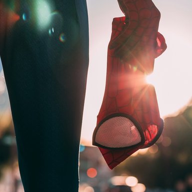 Eine Hand hält eine Spider Man Maske.