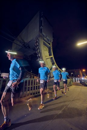 Eine Langzeitbelichtung: Ein Läufer ist dupliziert an mehreren Stellen auf der Eisenbahnbrücke zu sehen.