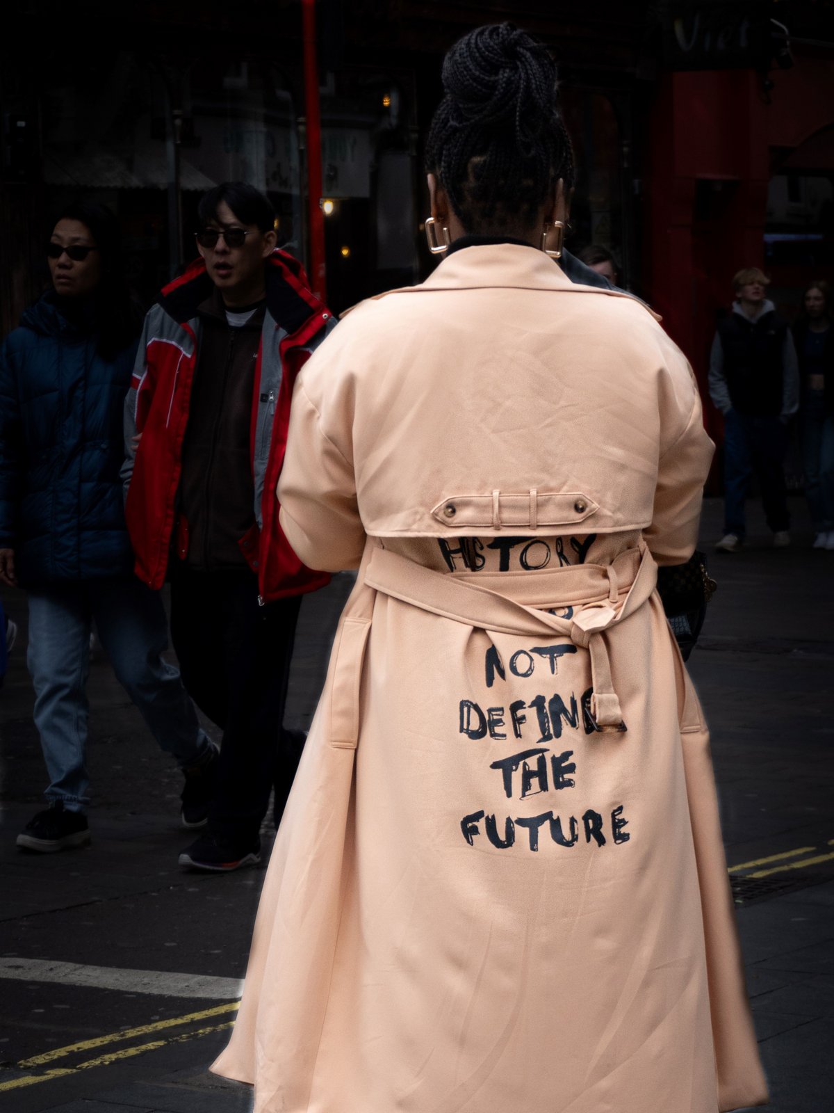 Bild: Carina Seyen Eine Frau mit der Aufschrift History does not define the future auf ihrem Mantel.