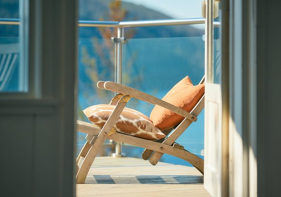 Blick auf einen Balkon mit Sonnenstuhl.