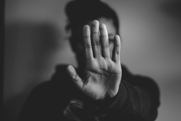 Eine Frau streckt der Kamera eine Hand entgegen, um sich zu wehren.