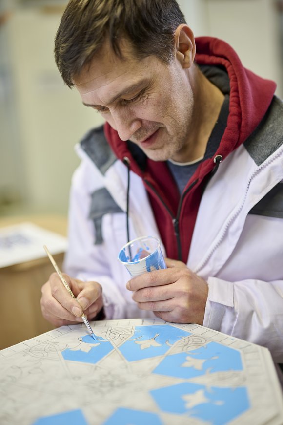 Ein Teilnehmer bemalt einen Hocker. Bild: Eiko Braatz