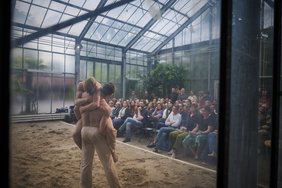 Bild: Eiko Braatz Blick von außen in das Gewächshaus über das tanzende Duett in das Publikum