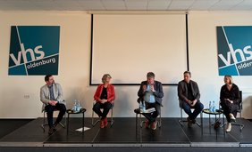 Bild: VHS Oldenburg Niklas Howad (CDU Oldenburg), Susanne Menge ( Grüne Oldenburg), Moderator Siebo Janssen, Dr. Gero Büsselmann (FDP Oldenburg) und Nicole Piechotta (SPD Oldenburg) auf dem Podium.