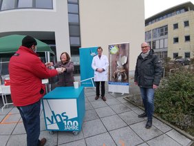 Dagmar Sachse überreicht eine Tüte und eine Suppe zum Mitnehmen. Neben ihr stehen  Martin Bartsch und Andreas Gögel. ▪ Bild: VHS Oldenburg 