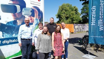 Andreas Gögel, Antje Schmidt-Kunert, Katharina Janßen, Magali Baudelet und Anita Groth (alle VHS Oldenburg) und , Nils Erpenbeck (Entwickler des DigiMobils) vor dem DigiMobil. Bild: VHS Oldenburg. 