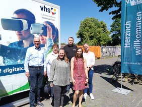 Andreas Gögel, Antje Schmidt-Kunert, Katharina Janßen, Magali Baudelet und Anita Groth (alle VHS Oldenburg) und , Nils Erpenbeck (Entwickler des DigiMobils) vor dem DigiMobil. Bild: VHS Oldenburg. 