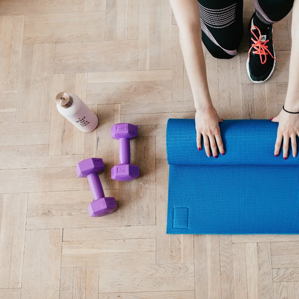 Eine Person rollte eine Gymnastikmatte ein.