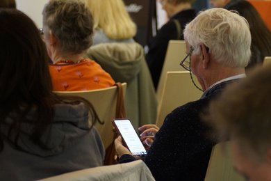 Das Publikum beantwortet an Smartphones die Fragen anhand derer sie ihre Gesprächspartner finden.