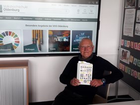 Klaus Maaß mit einem Exemplar von „Heraus mit den Sprachen“. Bild: Heidi Scharvogel.