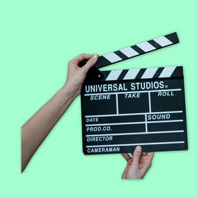 Eine Hand hält eine Filmklappe