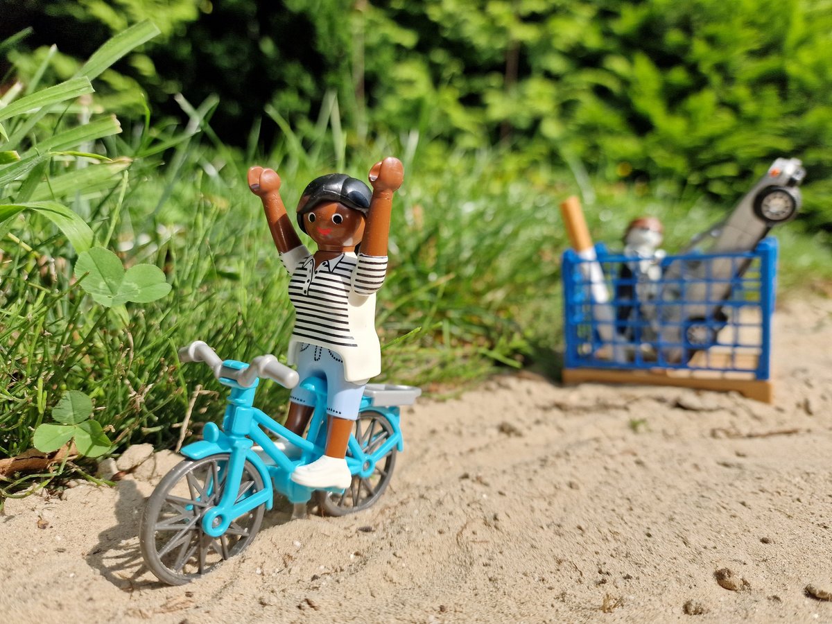 Bild: Sabine Hergert Eine Playmobilfigur auf einem Fahrrad neben einem Spielzeugauto und einer Zigarette in einem Spielzeugpapierkorb.