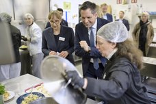 Ministerpräsident Olaf Lies schaut in der Lehrküche in einen Topf.