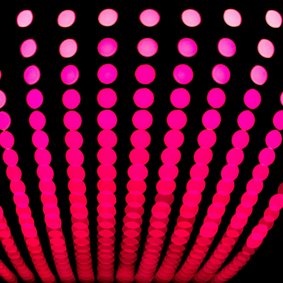 Eine Matrix aus Scheinwerferspots, die weiter nach oben von pink zu weiß wechseln