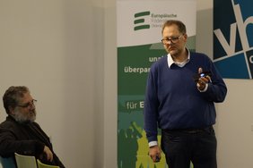 Gast Matthias Brucke demonstriert dem Publiku, wie er mit seinem ChatGPT auf seinem Smartpone spricht. Bild: VHS Oldenburg