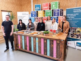 Judith Busch, Tanja Meiser und das Team der OWJ mit Jugendlichen an der Outdoorküche der Jugendwerkstatt. Bild: VHS Oldenburg.