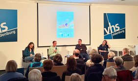 Bild: VHS Oldenburg Gespräch auf dem Podium mit Leonie Craes (Misereor,) , Daniel Shenhar (NGO HaMoked) sowie Moderator Peter Meiwald und einer Übersetzerin.