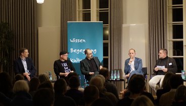 Blick vom Publikum auf Teile des Podiums im Gespräch.  Bild: VHS Oldenburg