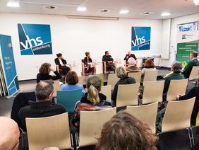 Das Podium diskutiert vor Publikum.