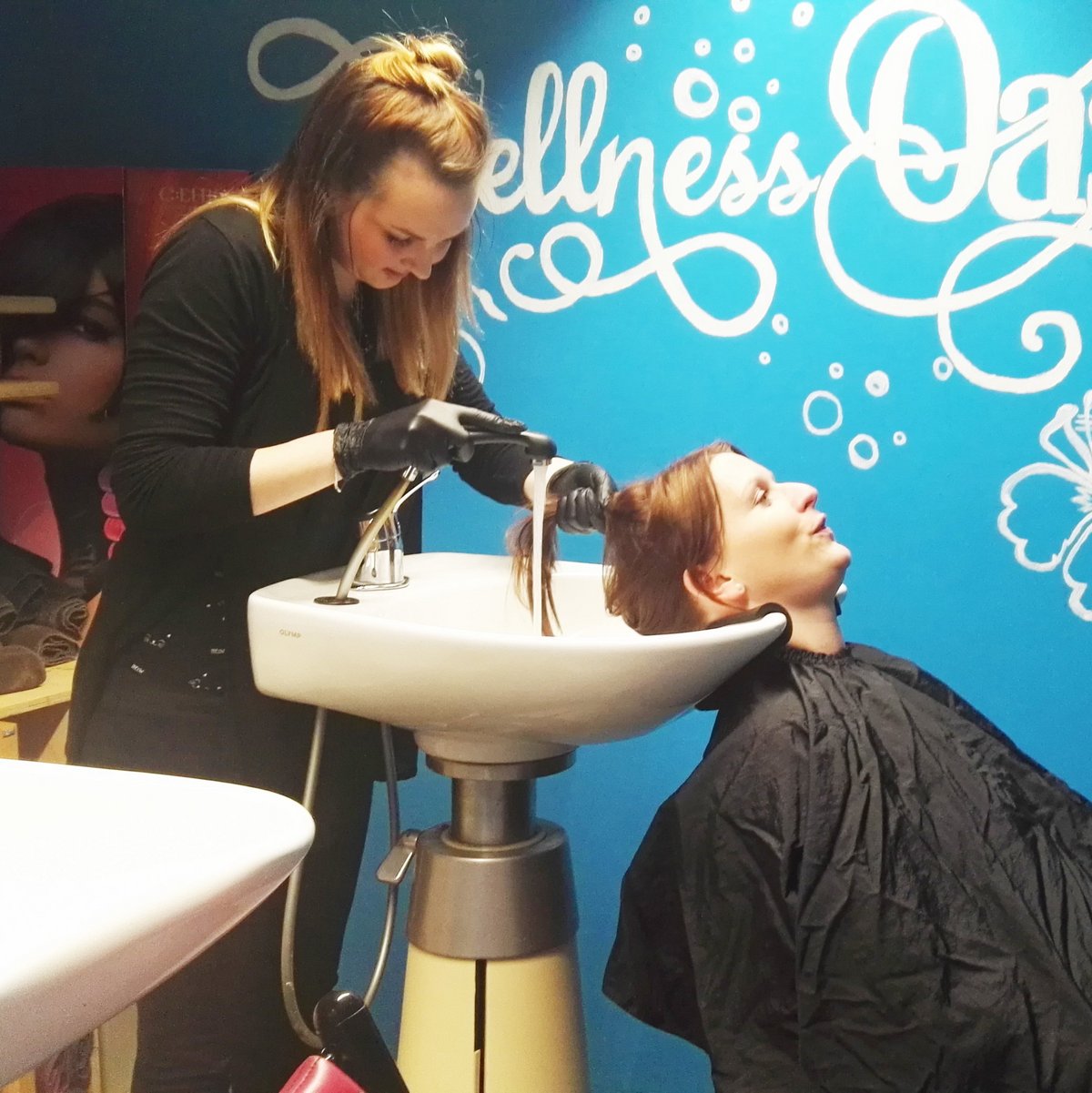 Alischa wäscht im Salon der Jugendwerkstatt LUPO die Haare einer Teilnehmerin.