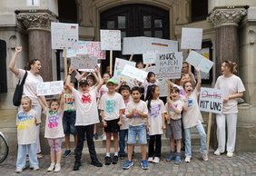 Bild: VHS Oldenburg Die Kinder mit ihrem Transparent, ihren Schildern und Tshirt vor dem Rathaus.