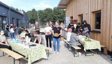 V.l. stehend: Anne Bohlen (Bereichsleitung Projekte, VHS Oldenburg), Olga Vinnica (JANUN), Tanja Meiser (Pädagogische Leitung Oldenburger Jugendwerkstatt), Judith Busch (Ernährungsrat Oldenburg), Sabine Höhne, (Bereichsleiterin Markt & Integration, Jobcenter Oldenburg) und die Teilehmer*innen der Oldenburger Jugendwerkstatt. Bild: VHS Oldenburg