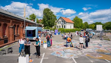 Personen beim fair ground vor der Exhalle
