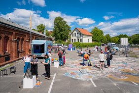 Personen beim fair ground vor der Exhalle