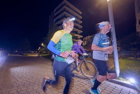 Zwei Läufer im Quartiert an der Doktorsklappe. Im Hintergrund fährt Mitorganisator Michael Groth auf dem Fahrrad vorbei.