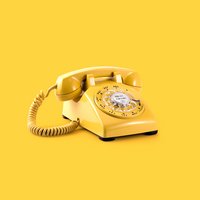 Ein gelbes Telefon mit Wählscheibe-