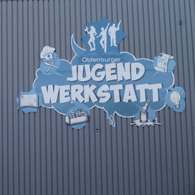 Bild: VHS Oldenburg. Graffiti an der Fassade der Oldenburger Jugendwerkstatt am Standort Pophankenweg.