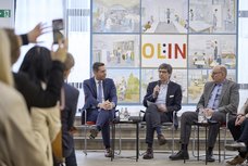 Blick aus dem Raum auf das Podium im Gespräch.