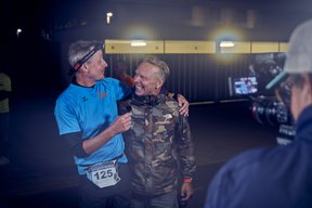 Ein Läufer legt im Ziel einen Arm um Mitorganisator Michael Groth.