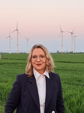 Bild: privat Claudia Kemfert vor einem Feld mit Windkraftanlagen