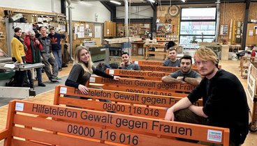 Team und Jugendliche der Oldenburger Jugendwerkstatt auf den orangenen Bänken. Bild: VHS Oldenburg