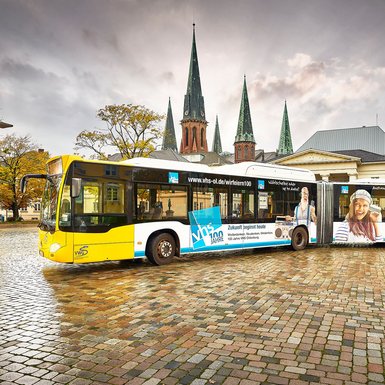 Der VHS-Bus auf dem Schlossplatz. Im Hintergrund die Lambertikirche. Bild: Volker Kunkel Fotografie.