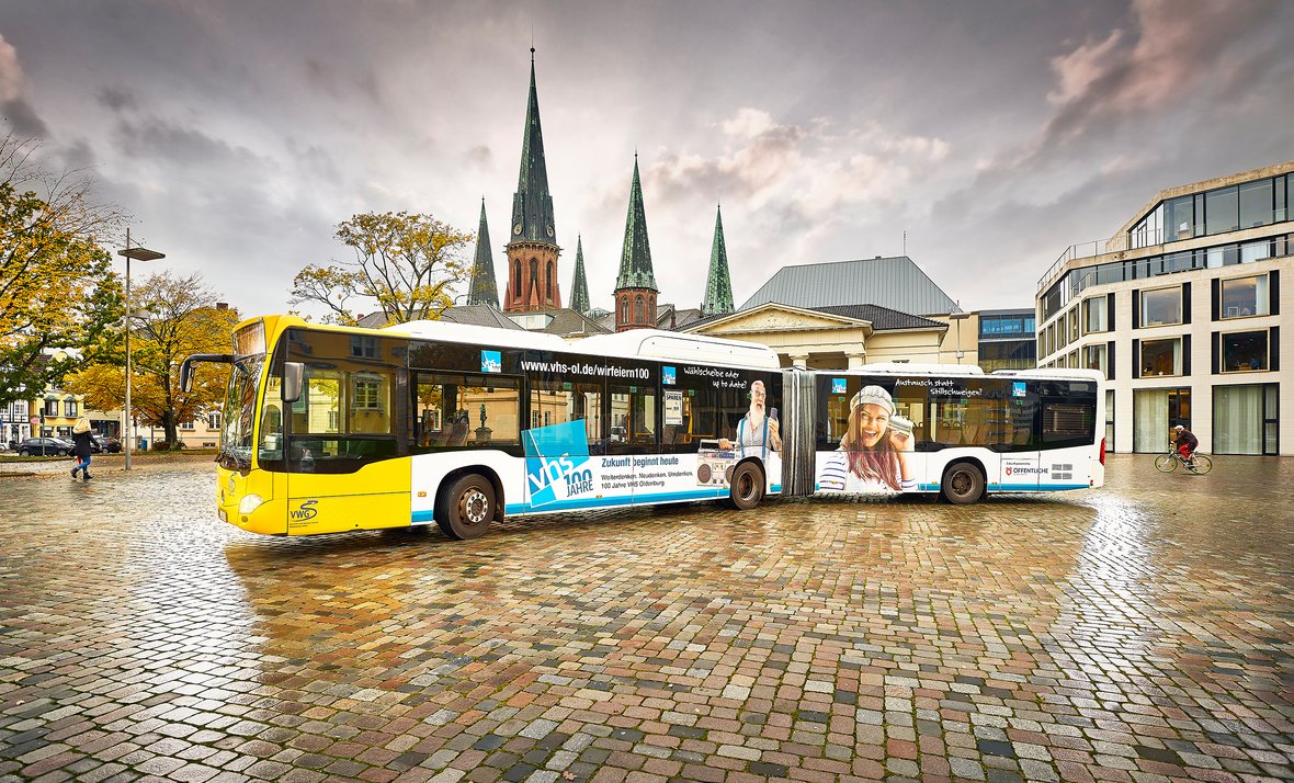 Der VHS-Bus auf dem Schlossplatz. Im Hintergrund die Lambertikirche. Bild: Volker Kunkel Fotografie.