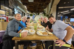 Eine Gruppe Teilnehmende beim Frühstück im Schirrmanns lächelt in die Kamera.
