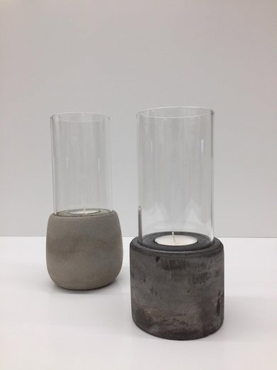 Ein Windlich aus Stein und Glas mit einem Teelicht.