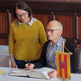 Bild: privat Gerry Hahlo trägt sich ins goldende Buch der Stadt Oldenburg ein.